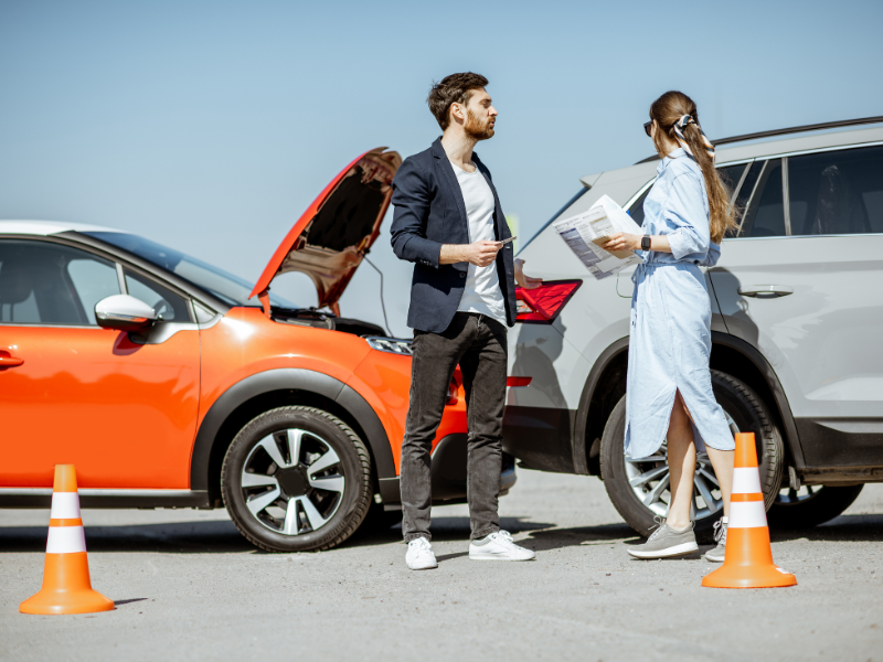 An image showing two people in an auto accident exchanging information in Alabama.