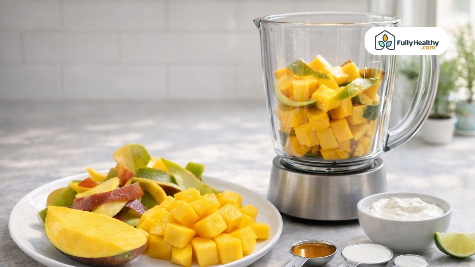 Blender with mango chunks and peel surrounded by ingredients on counter