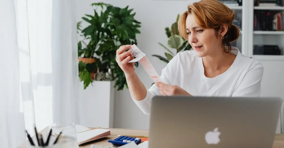 Woman reviewing receipts and bank statements for catch-up bookkeeping.