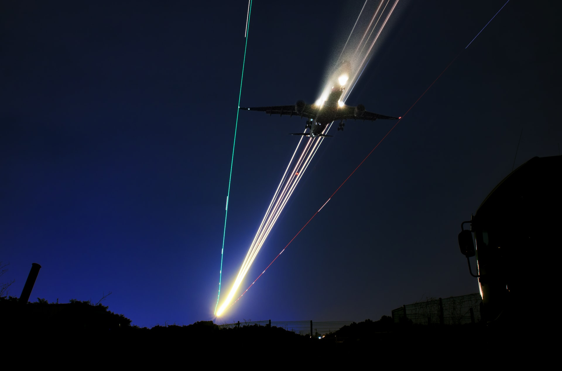 Long exposure photo with light trails of an aircraft landing at night. 