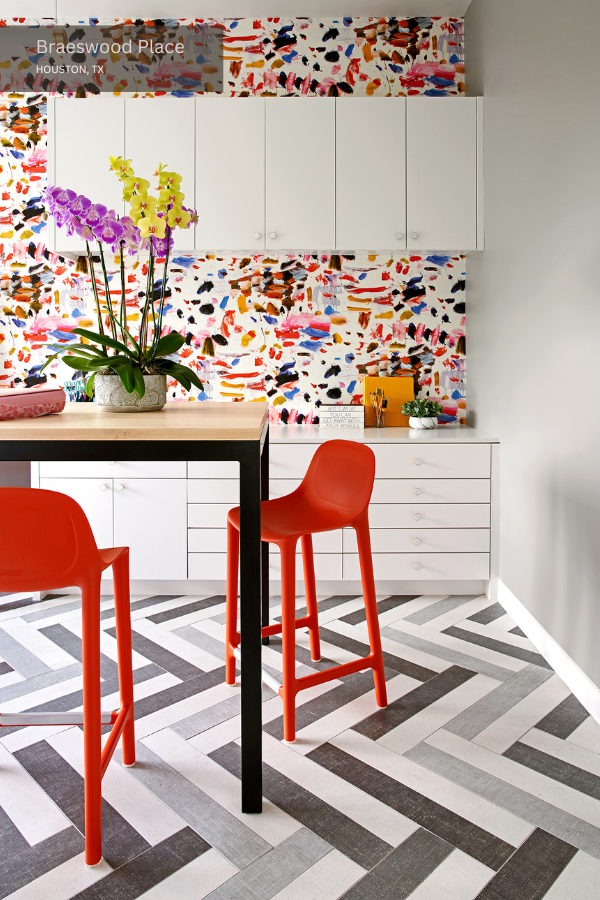 white cabinets, orange chairs, and a bar-height table in a craft room