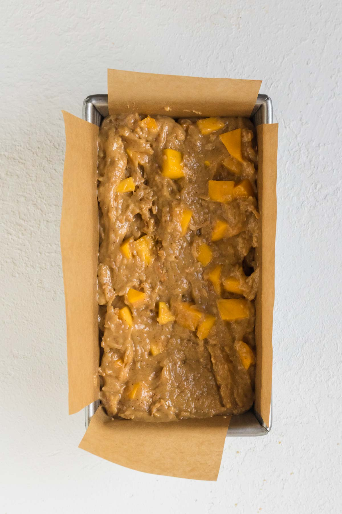 unbaked mango bread batter into the prepared pan