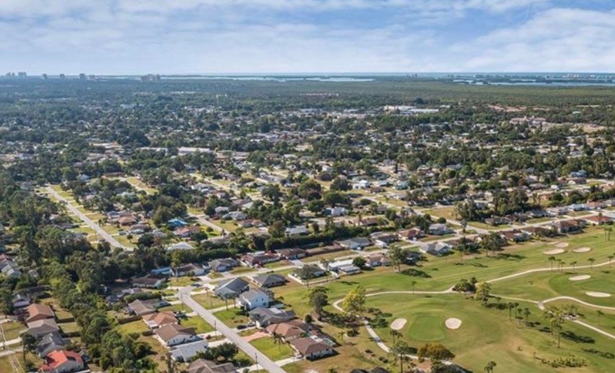 The image depicts Three Oaks Park, a beautifully planned living space in Fort Myers, FL, featuring recreational facilities and expansive green spaces perfect for outdoor living. The park offers a welcoming environment for both everyday living and leisure activities, making it a desirable destination in the San Carlos Park area.