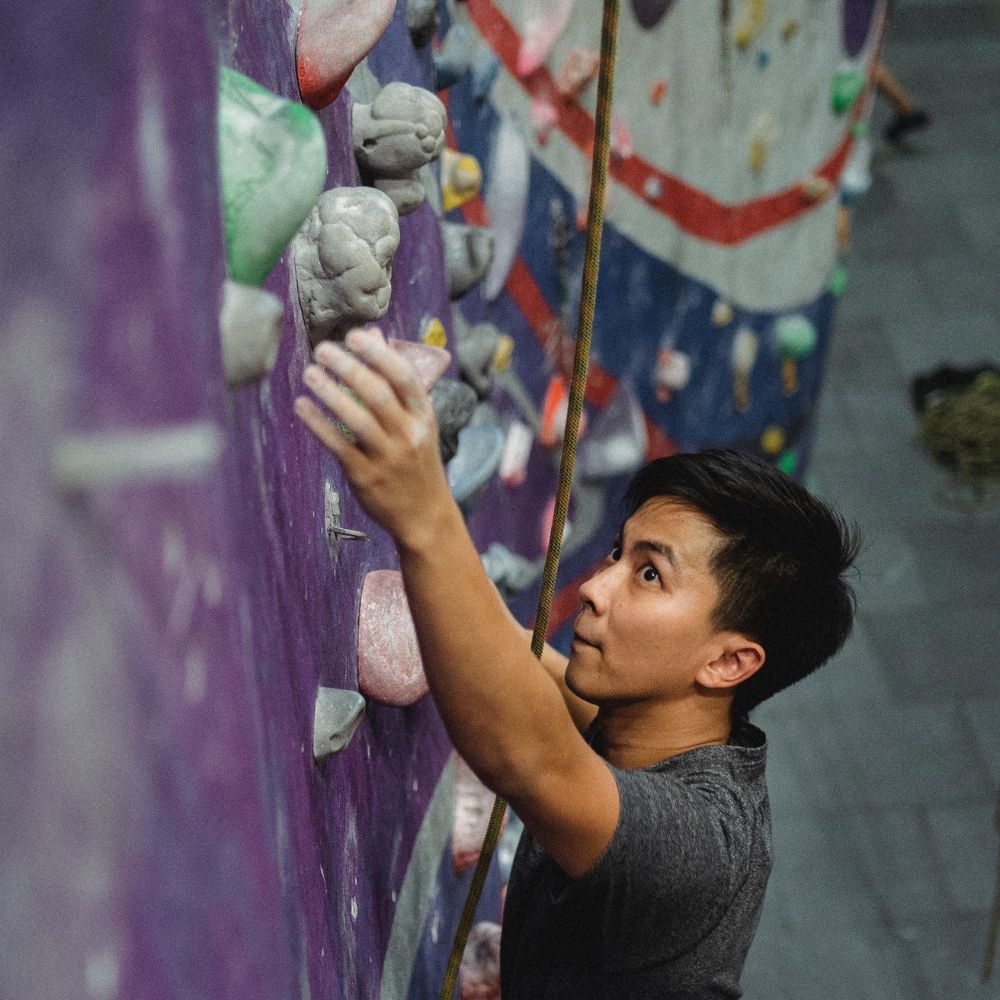 A person using chalk to increase grip strength while rock climbing