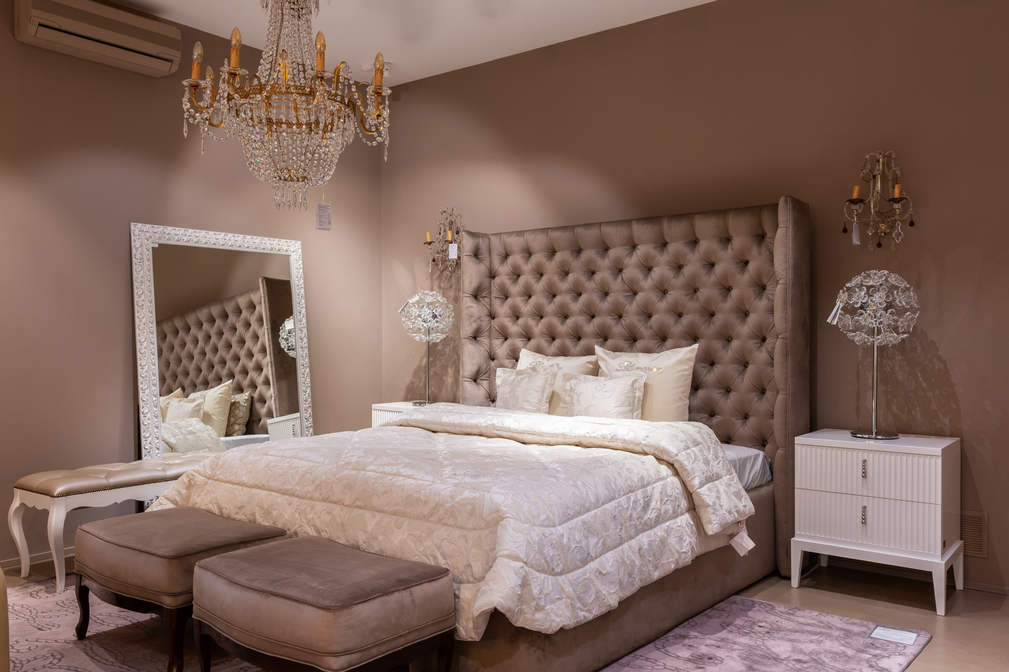 elegant bedroom with tufted headboard and oversized mirror