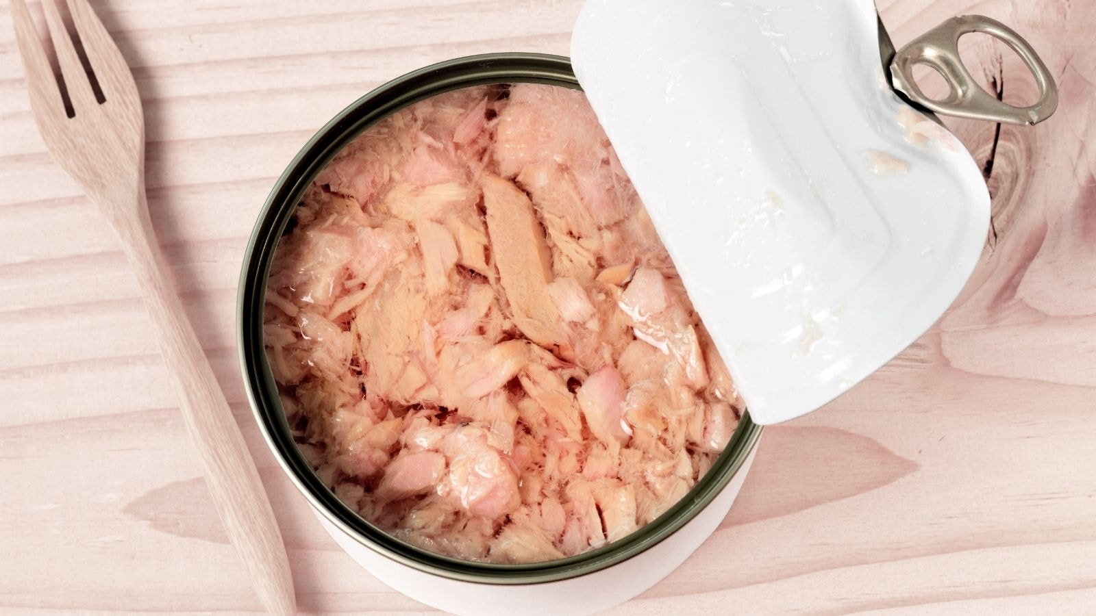 Open can of chunk light tuna showing pieces packed in oil