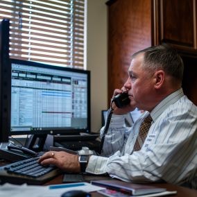 Insurance adjuster talking on the phone with a car crash victim