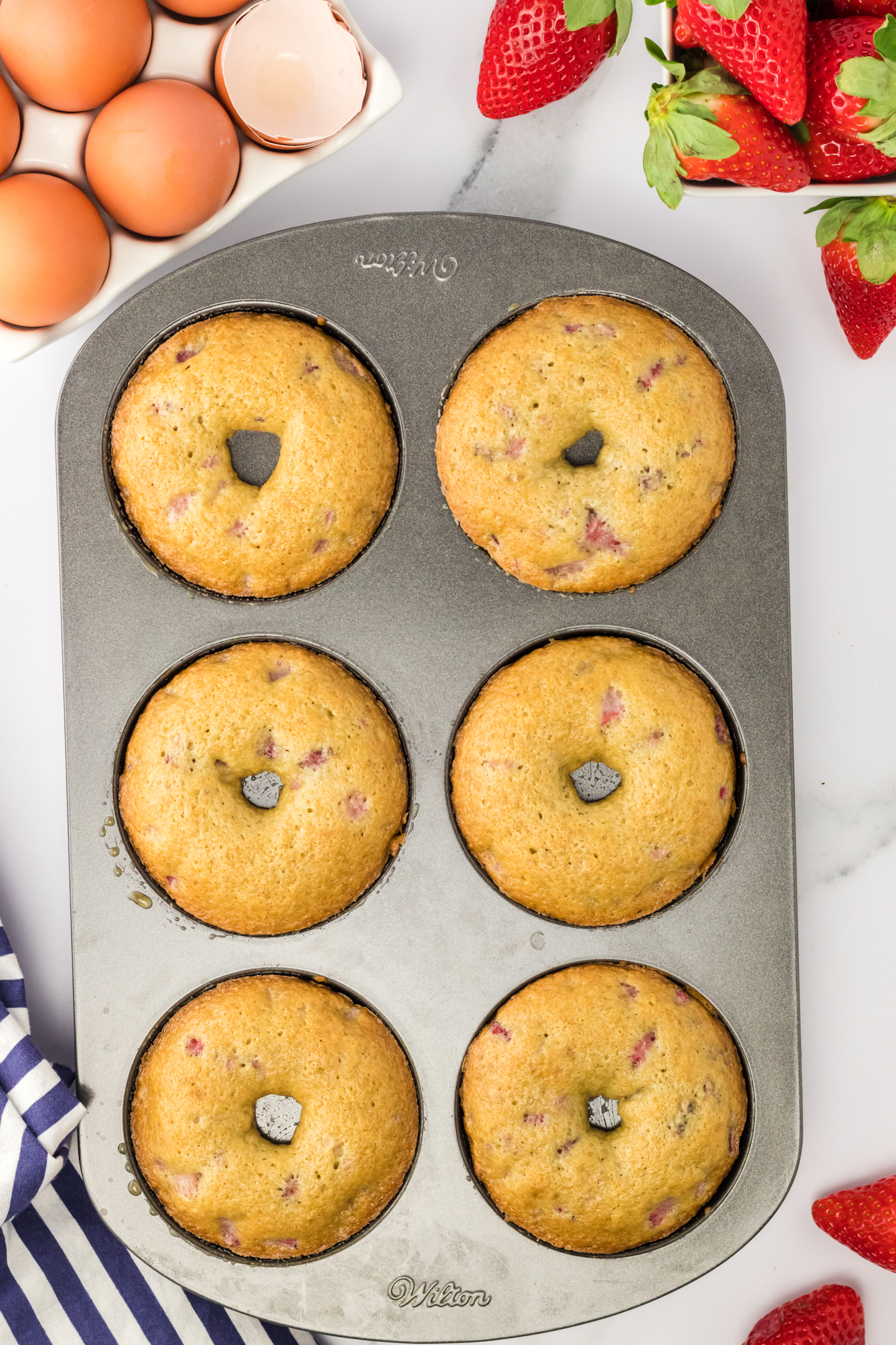 six baked strawberry donuts in donut pan
