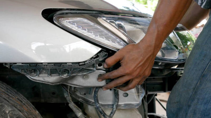 A professional replacing the headlight bulb.
