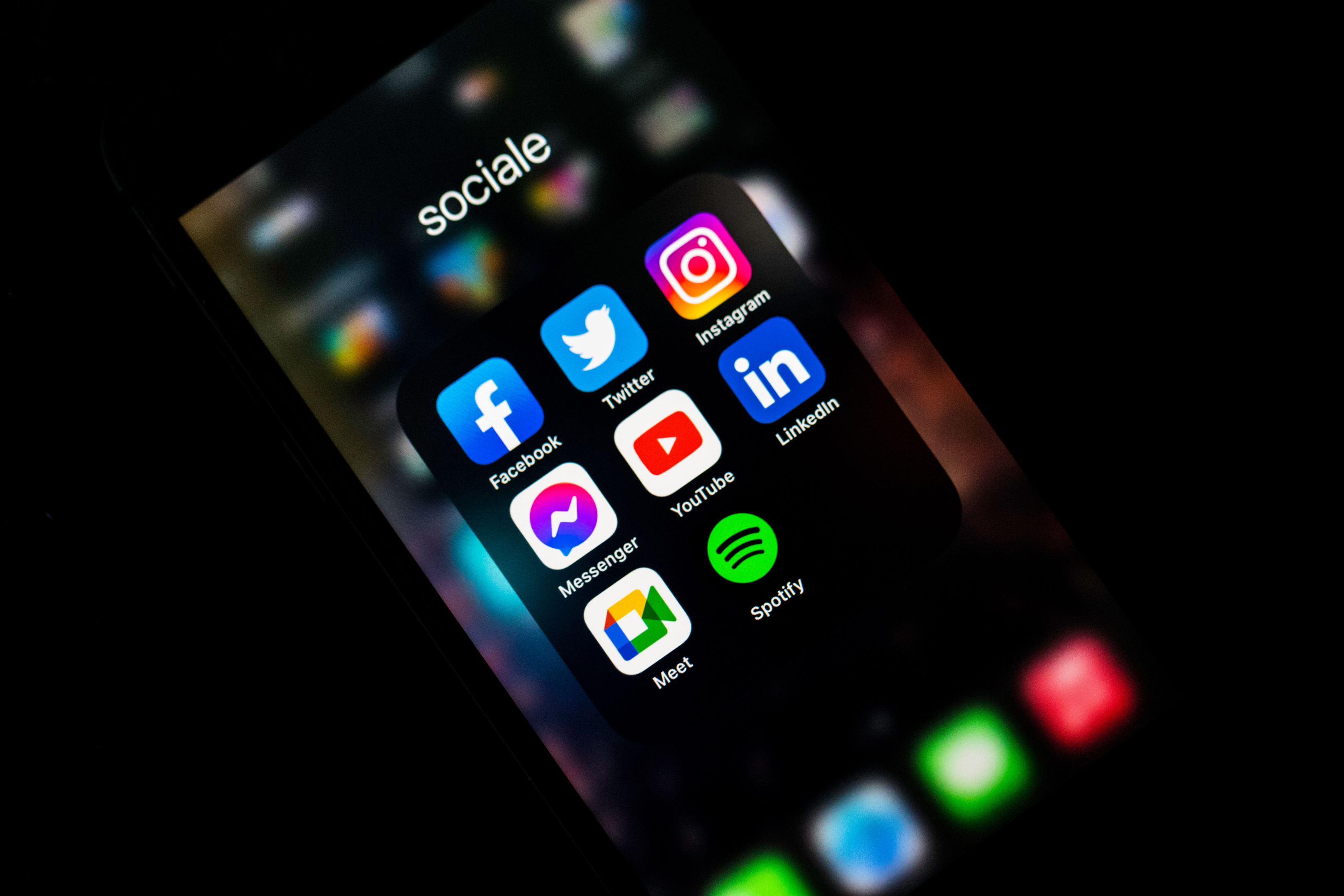 A smartphone in the dark with different social media platforms