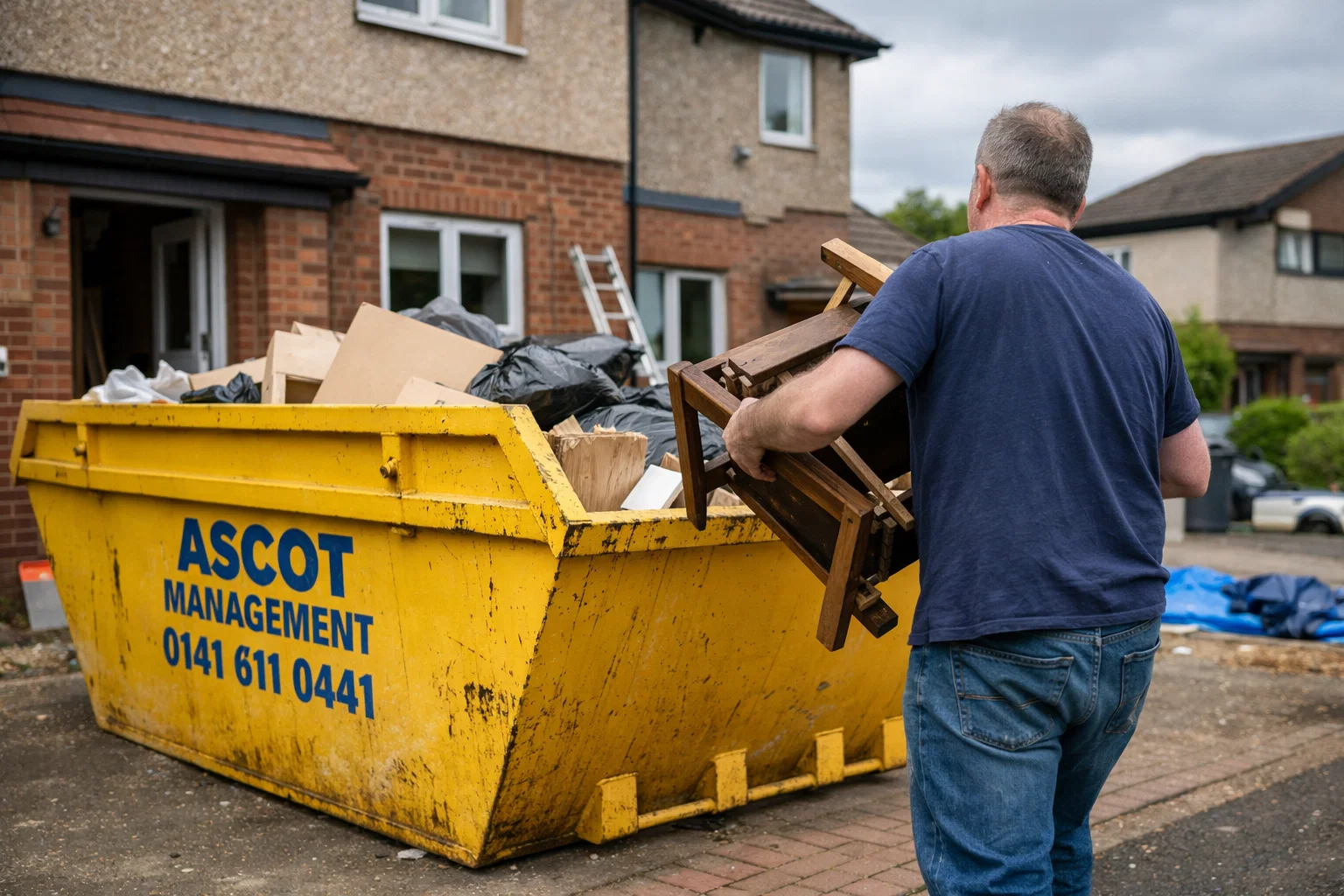 Homeowner placing furniture into a well-maintained Ascot Management skip during renovation in Glasgow.