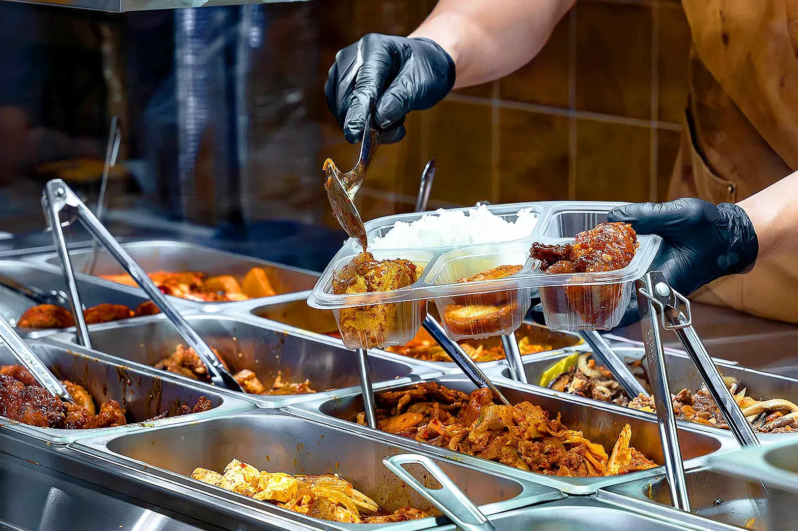 Korean takeaway meal being prepared at OGOG Singapore with rice, fried chicken, and traditional Korean side dishes.