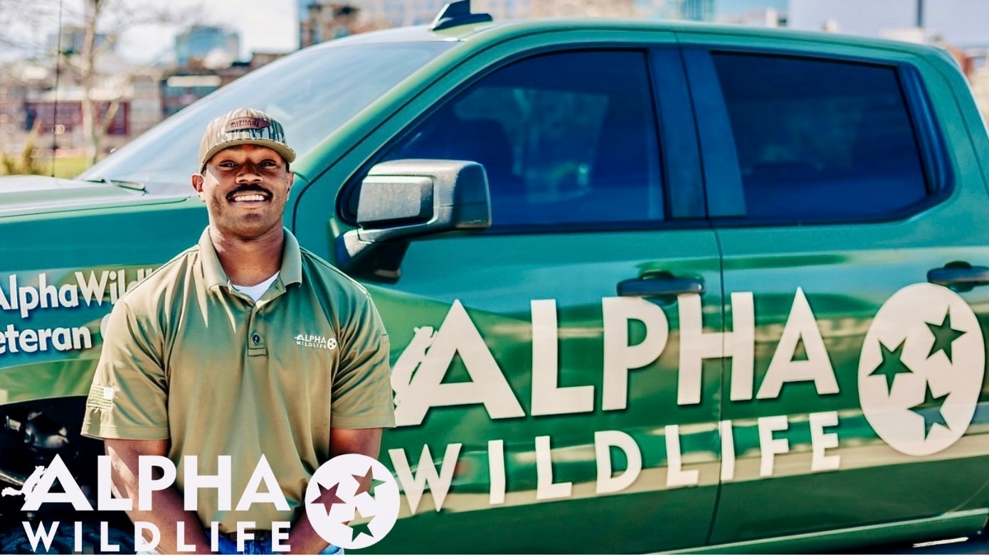 Alpha Wildlife technician standing in front of truck