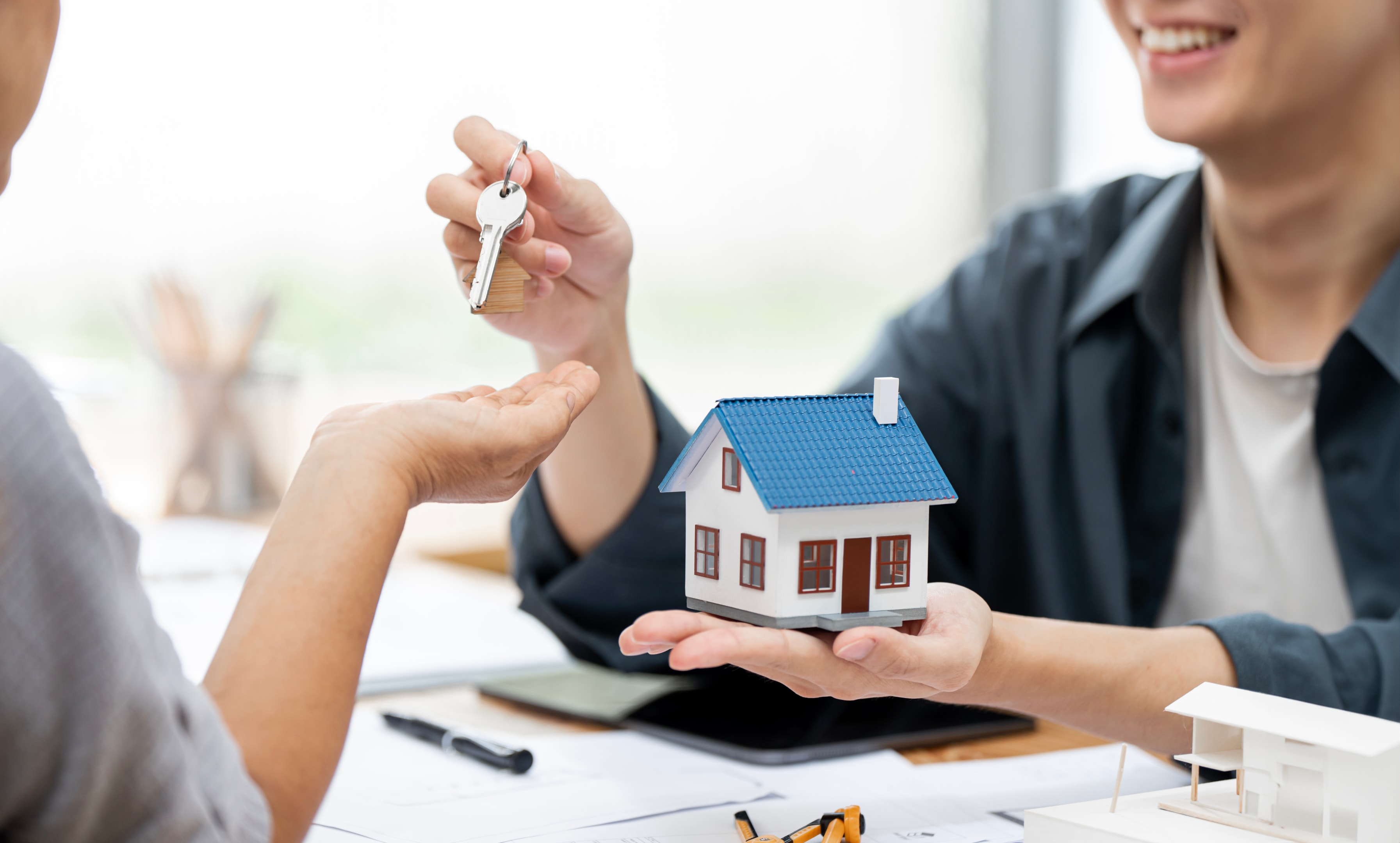 Real estate agent giving house key to customers