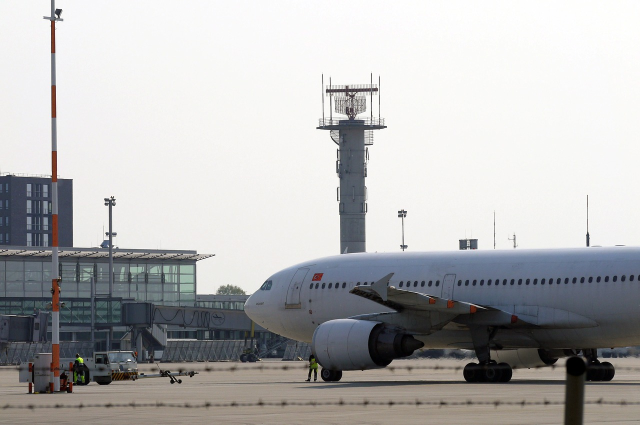 Air traffic threat: aircraft taxiing on tarmac in front of a radar tower.