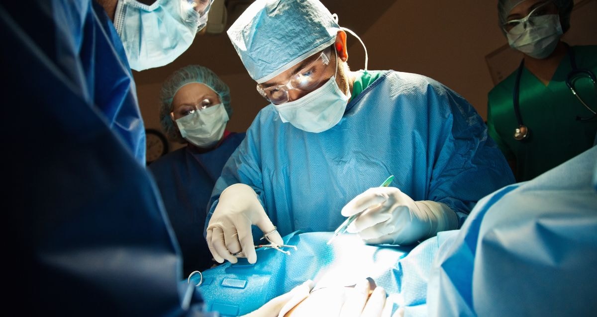 Gynecologist performing a c-section in the operating room on a prospective surrogate 