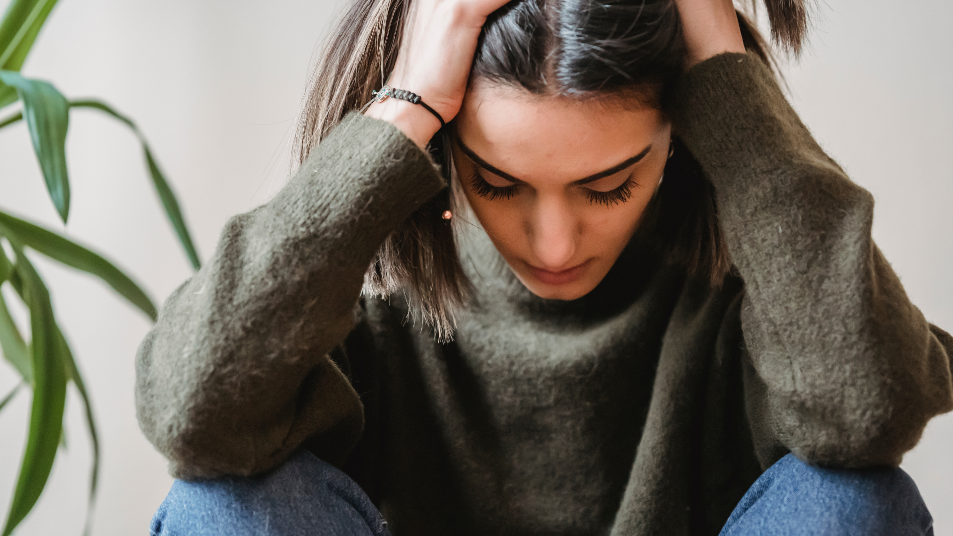 woman sitting on the floor with her hands on her head