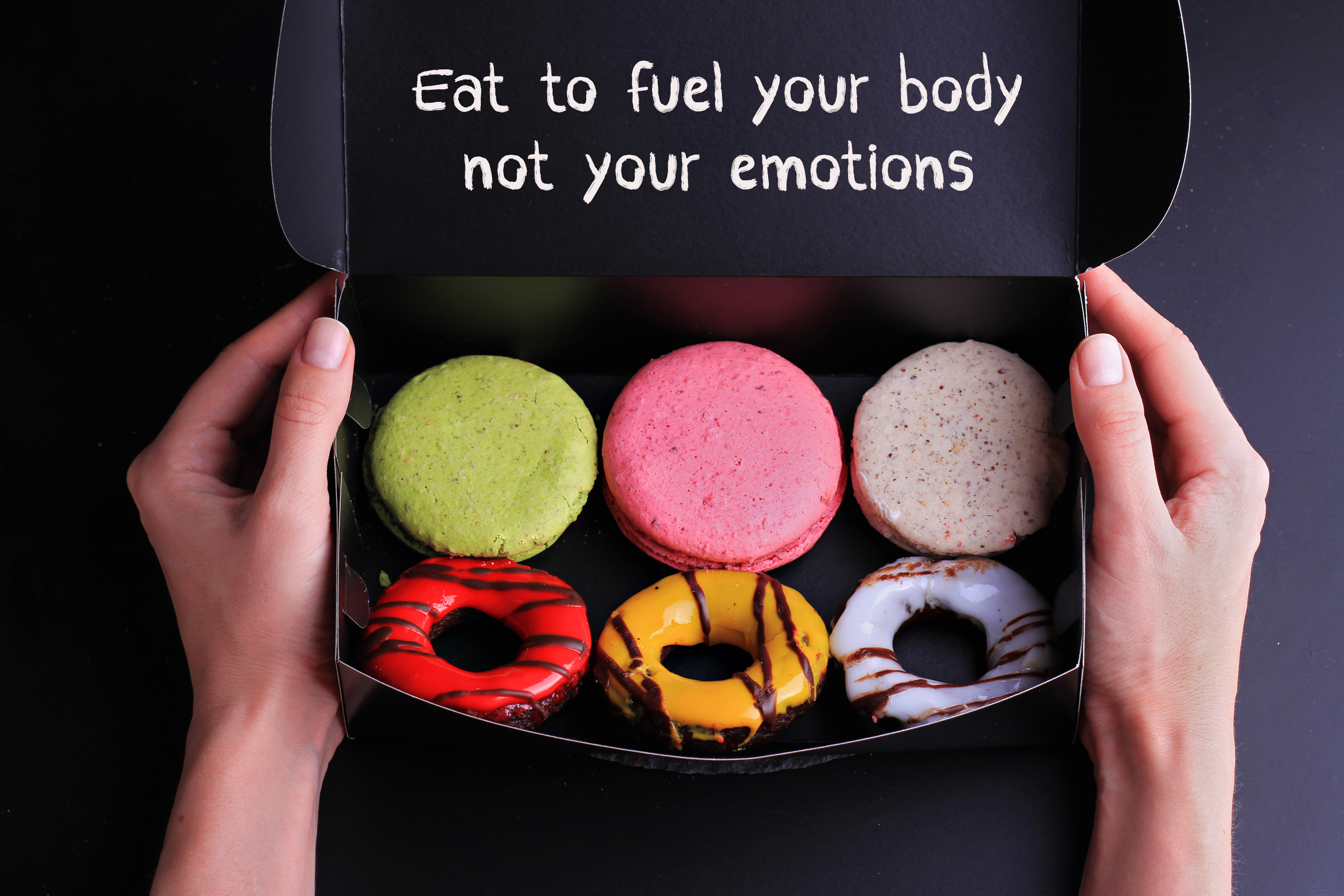 What is emotional eating? 6 snacks in a box with words saying "eat to fuel your body not your emotions." 