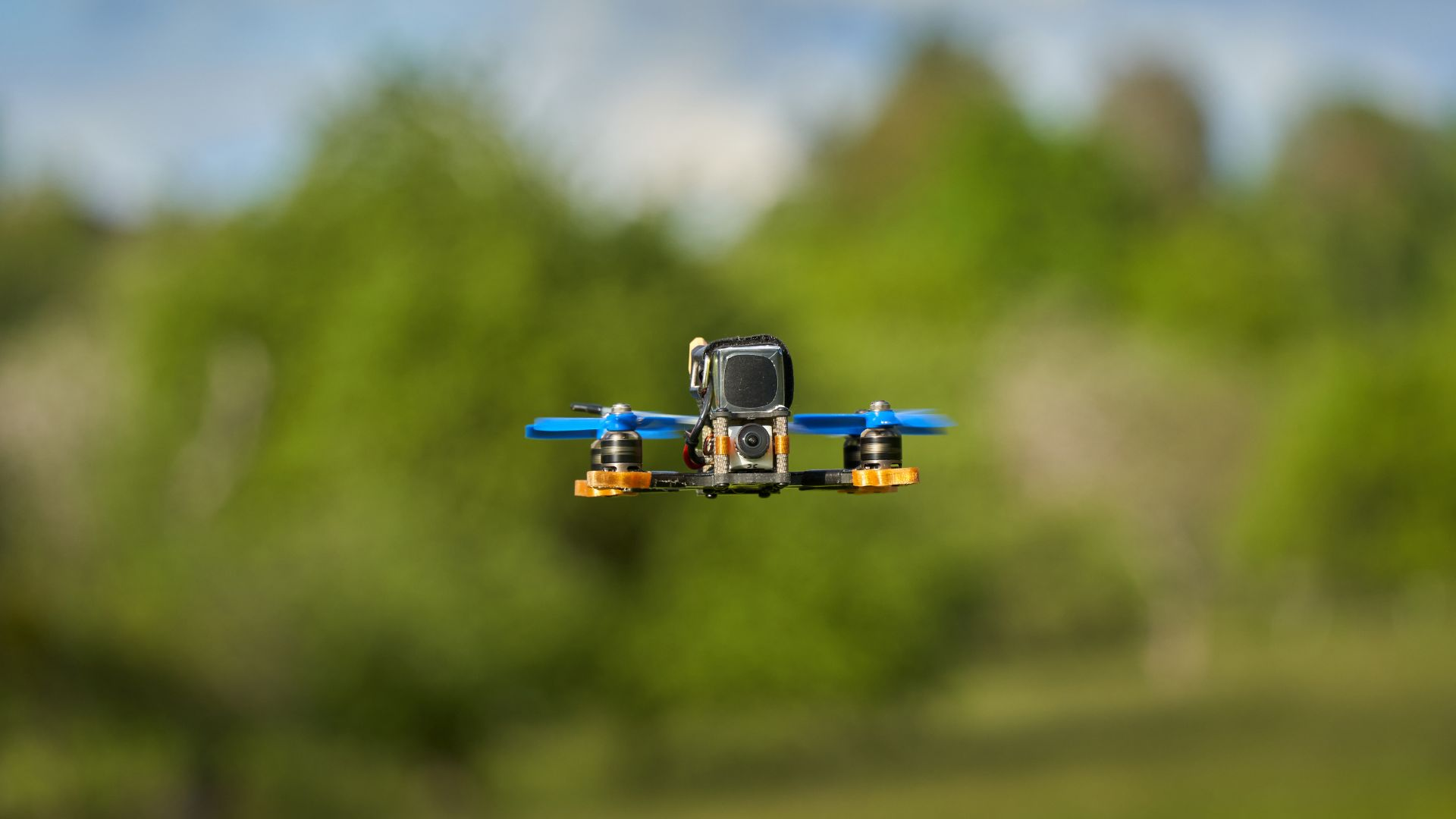 An image of a very small drone flying outside on a green background.