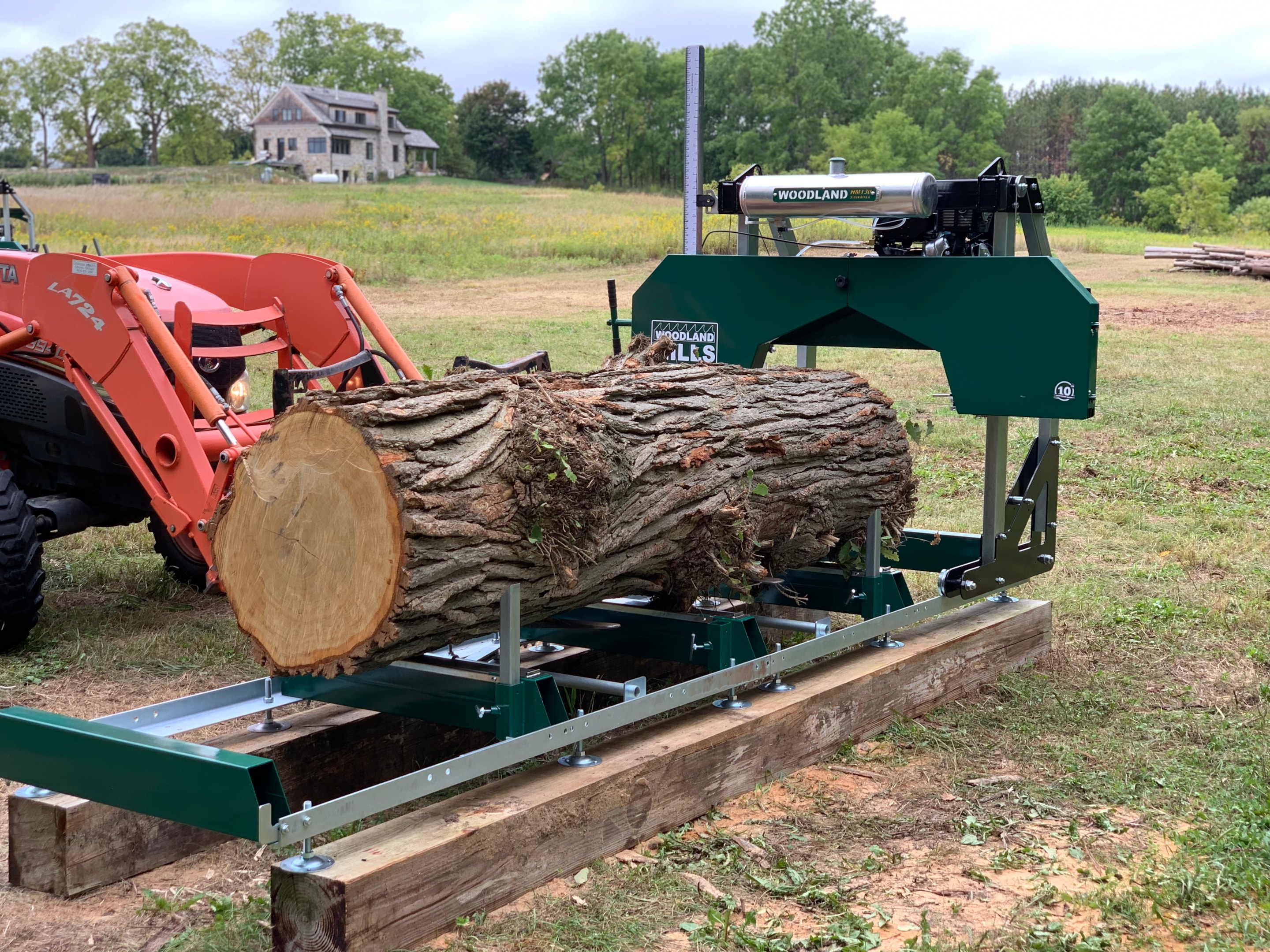 A Woodland Mills HM126 Portable Sawmill on a wooden track.