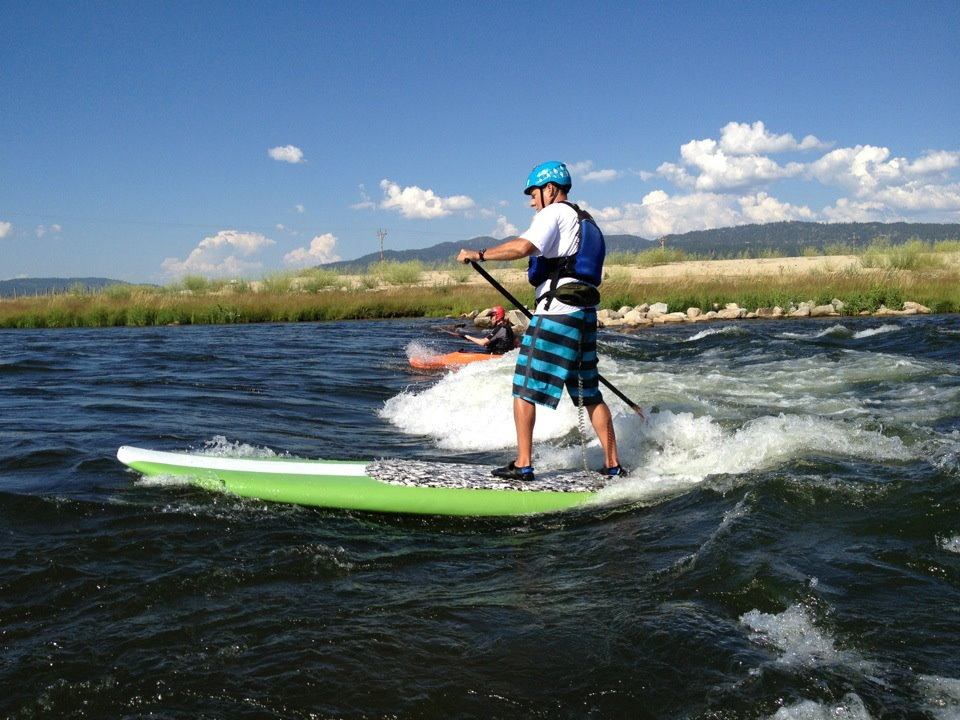stand up paddleboard on a river wave