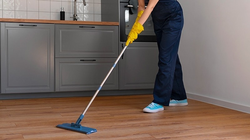 Women cleaning vinly floor with microfiber mop