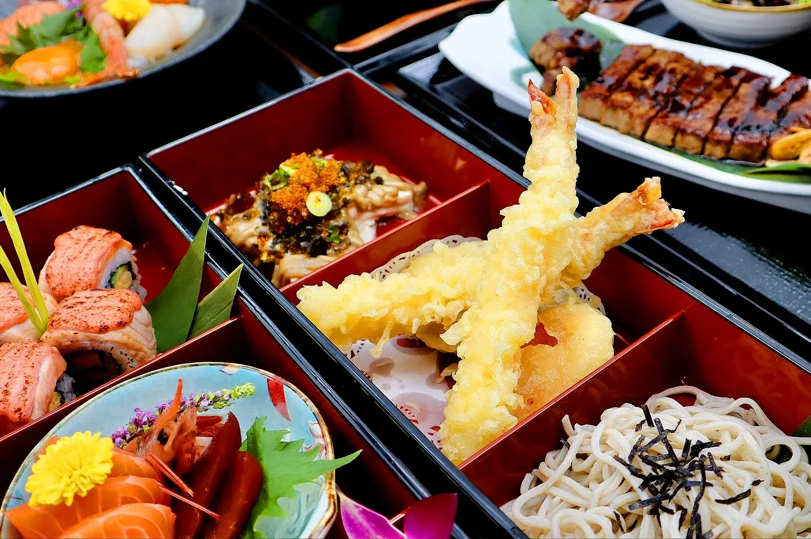 Japanese bento set featuring tempura prawns, sushi rolls, sashimi, udon noodles and grilled eel at a Japanese restaurant in Singapore