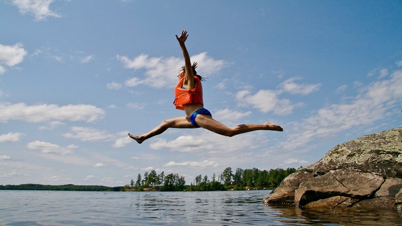 A Person with a Life Jacket Jumping into the River