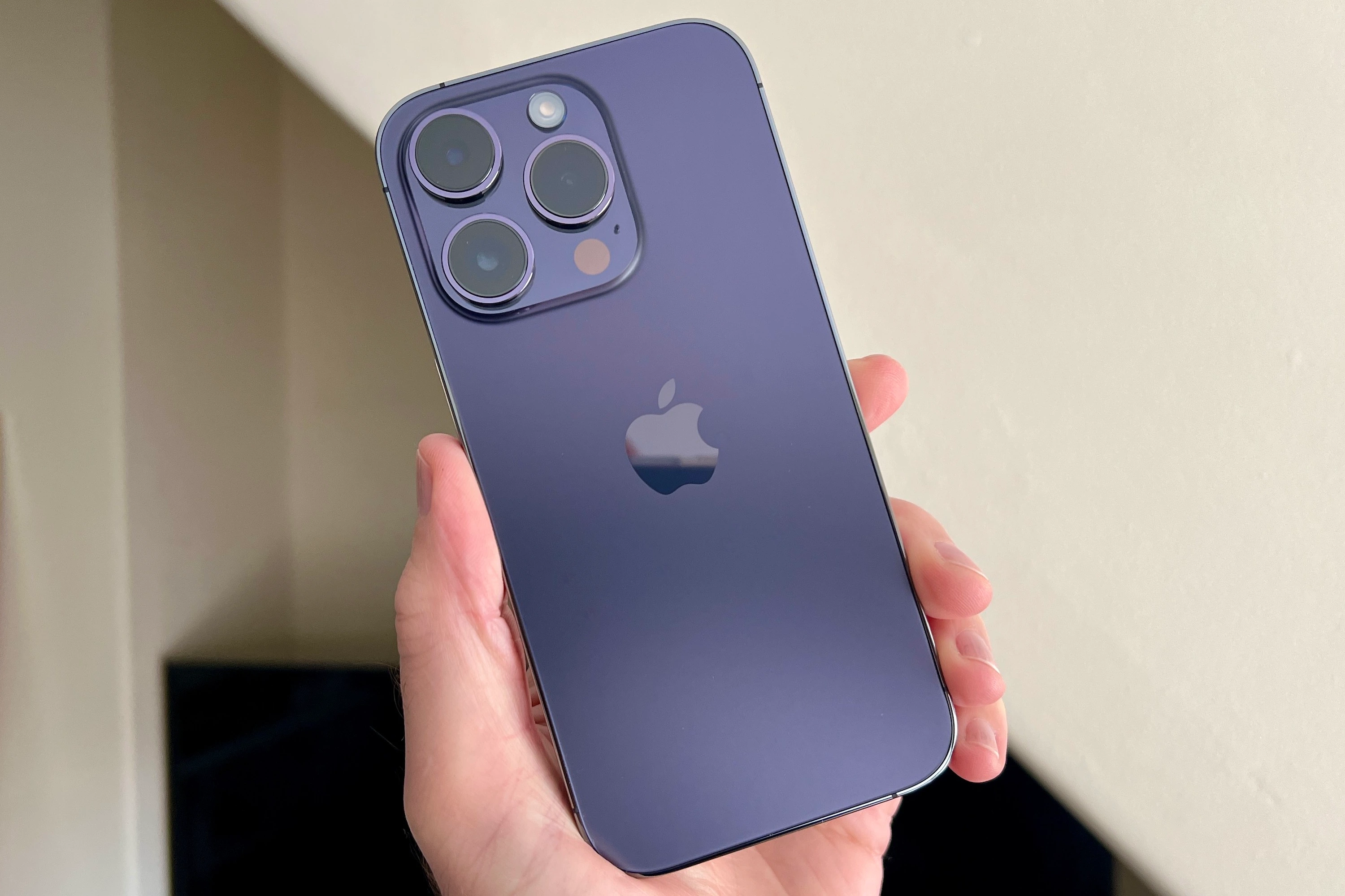 iPhone 14 Pro in a dark purple case.