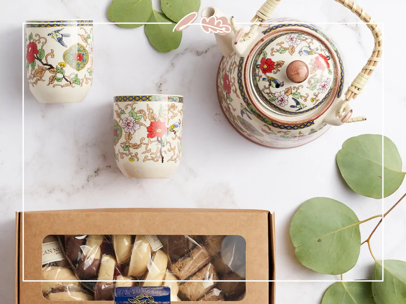 Elegant tea set with floral designs and a box of assorted treats, Fabulous Flowers and Gifts