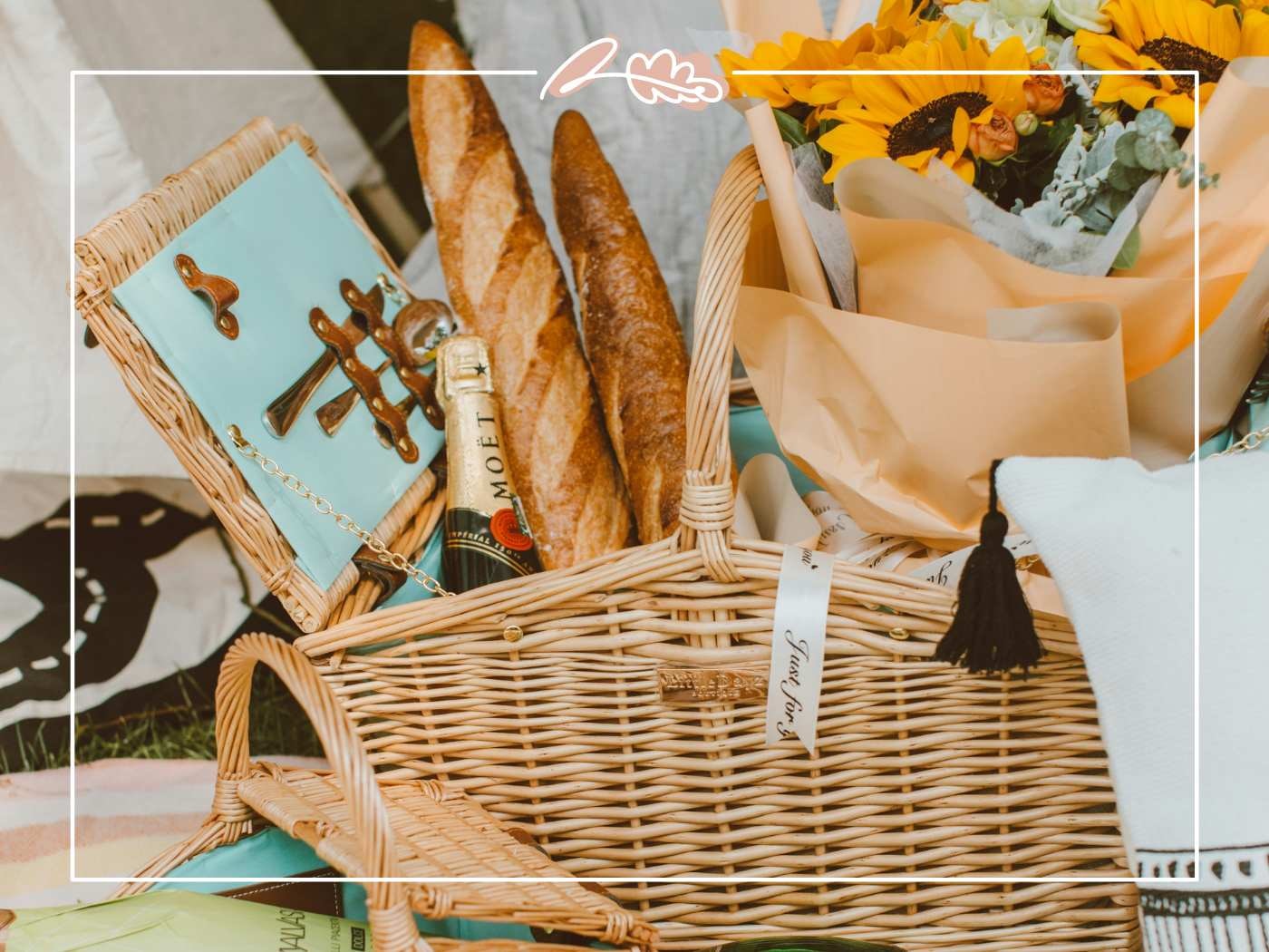 Picnic basket with bread, champagne, and sunflowers. A pleasure your friend will love.