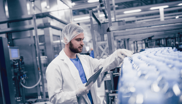 Pharmaceutical manufacturing worker checking product for quality control.