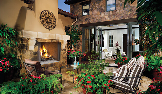 Traditional outdoor fireplace with a stone wall and a wooden bench