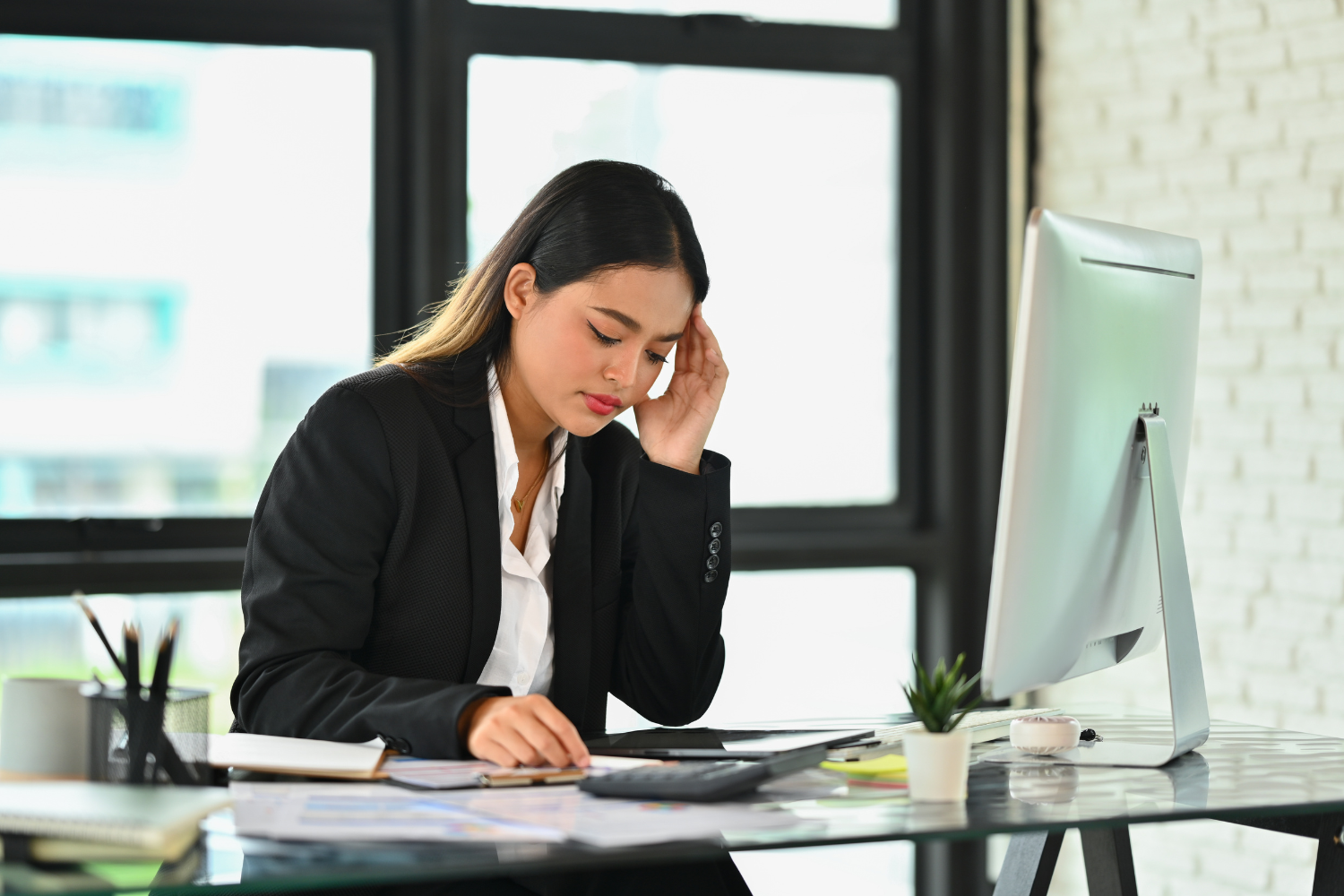 A confused remote worker sitting at a desk.