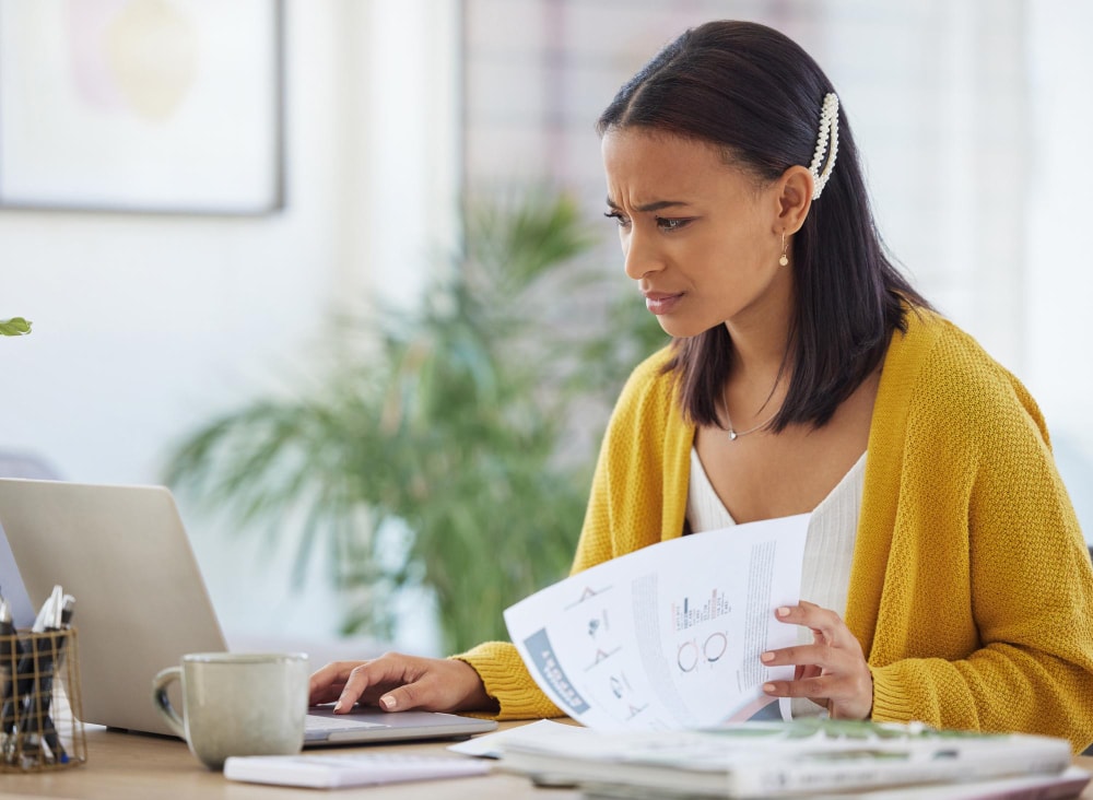 A frustrated and confused businesswoman trying to decide if she should cancel her traditional landlines for more cost savings.