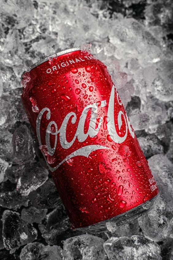 glistening coke can resting on ice cubes