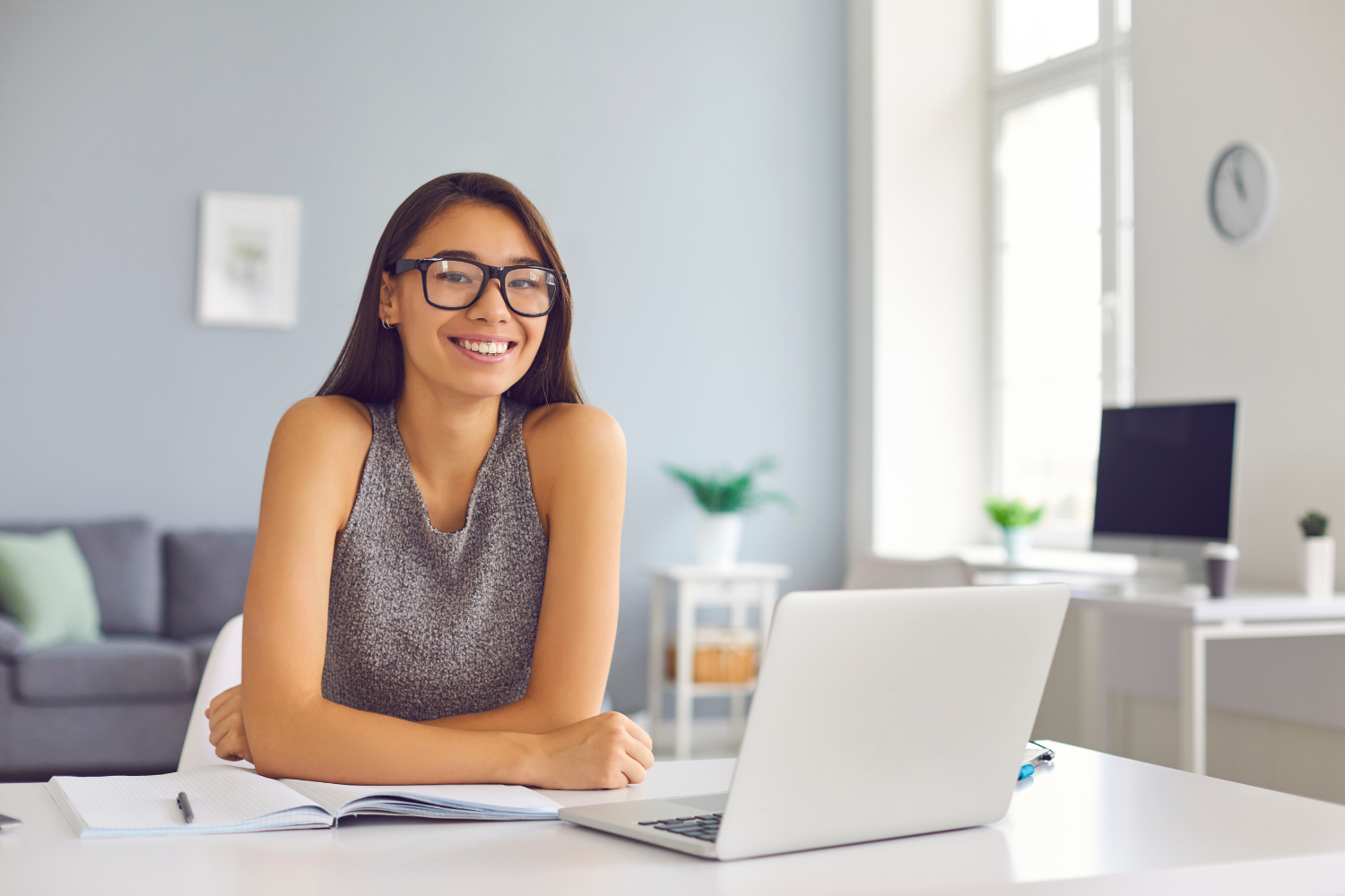 A smiling remote worker on her desk.