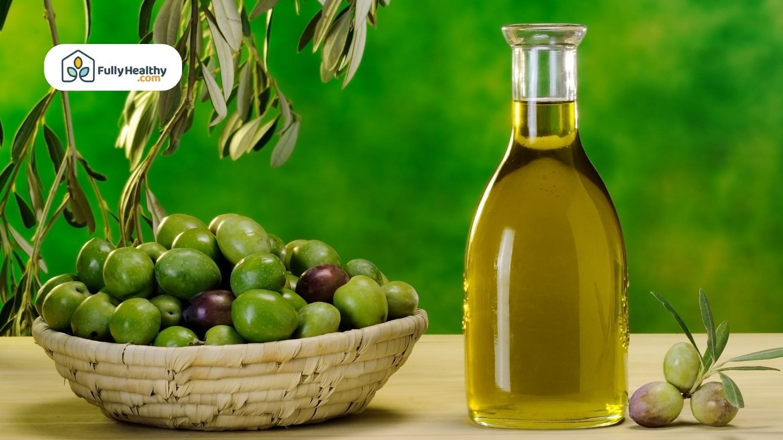 Basket of ripe green olives beside bottle of extra virgin olive oil.