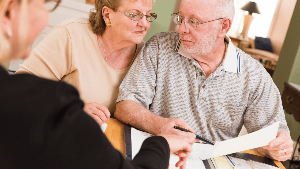 A senior couple discussing their legal matters with an elder law attorney