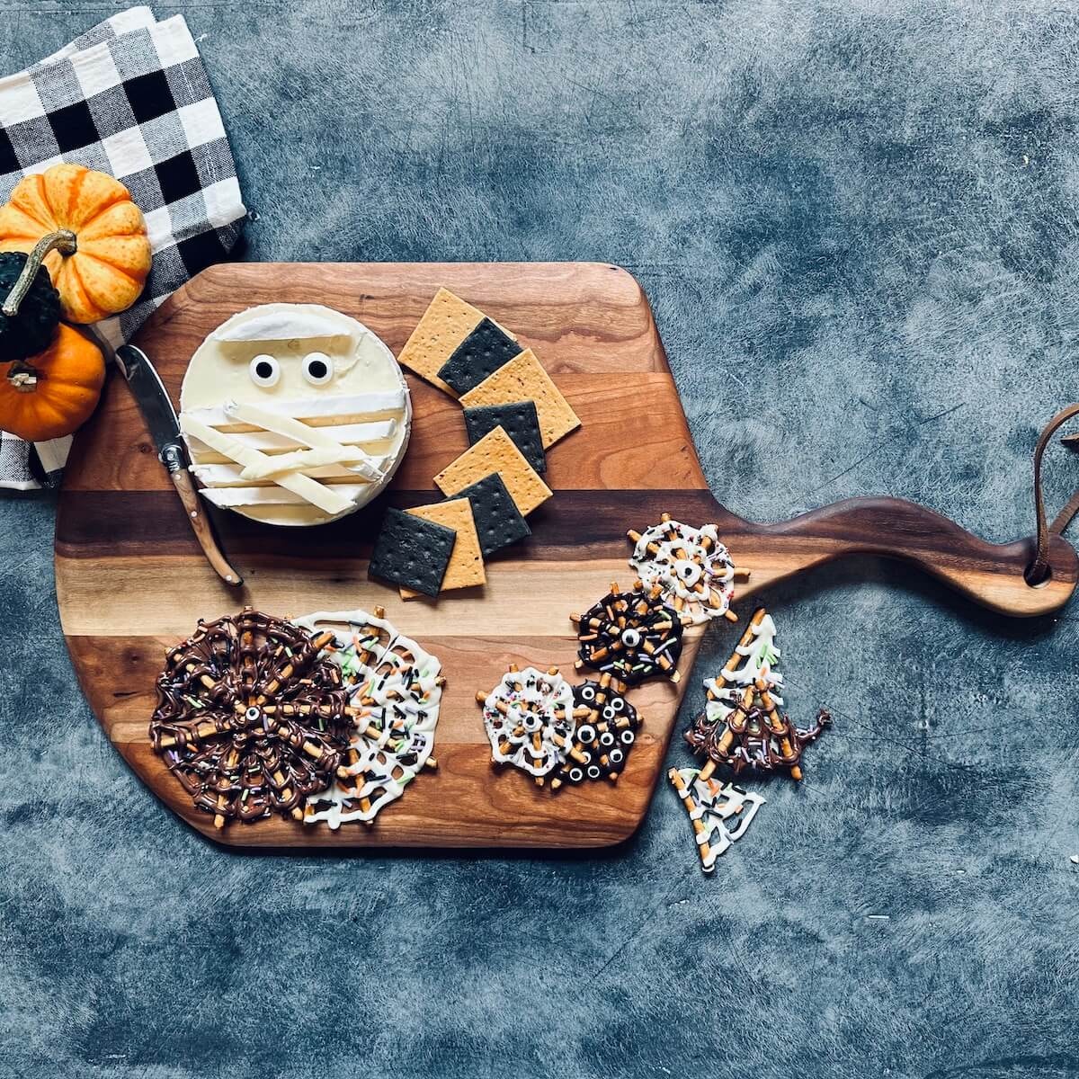 Halloween themed board with brie and chocolate spider webs