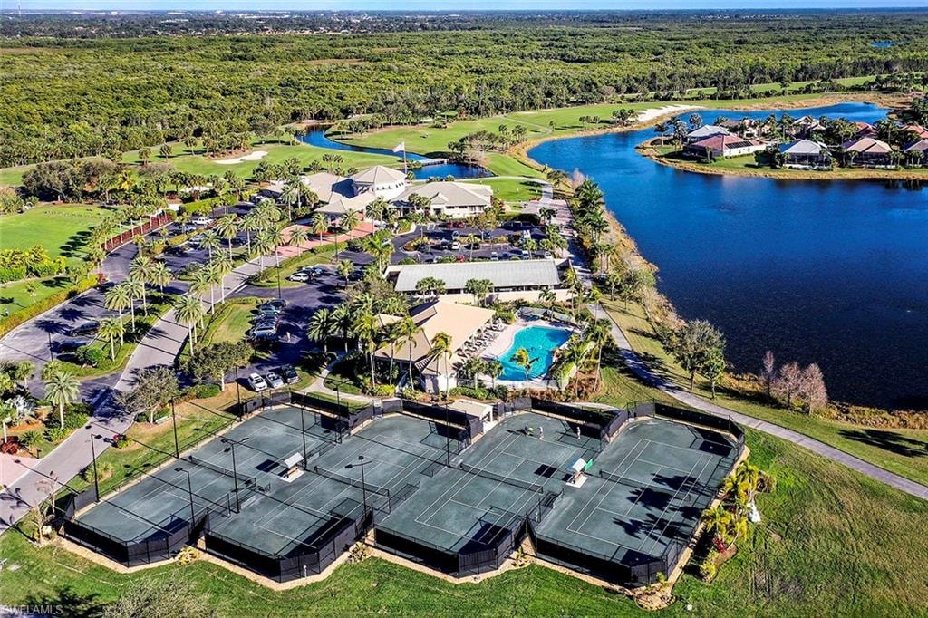 An aerial view showcases the lush fairways of the Crown Colony golf course in Fort Myers, Florida, surrounded by serene lakes and luxurious homes. The image highlights the beautiful community, ideal for prospective property consumers interested in Crown Colony real estate.