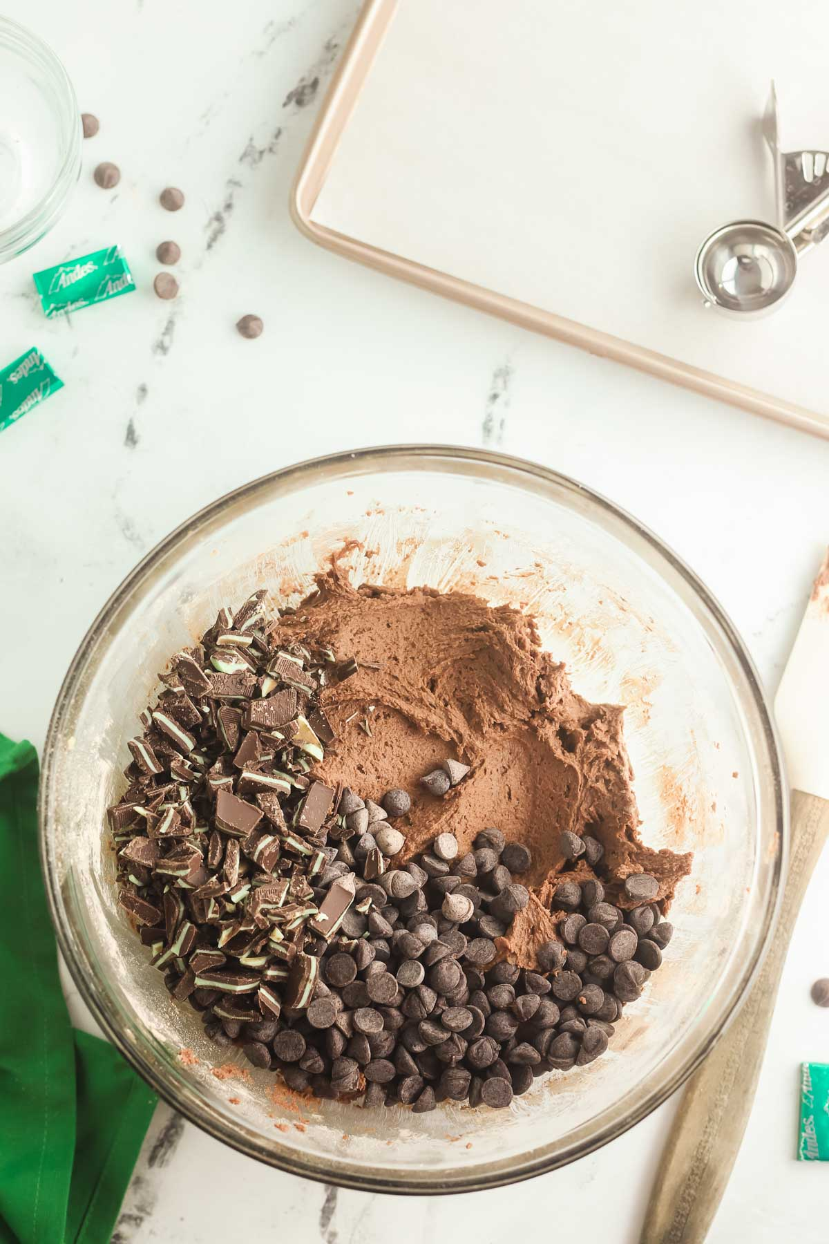 Andes mint chocolate cookie dough in bowl with chocoolate chips and Andes mints added.