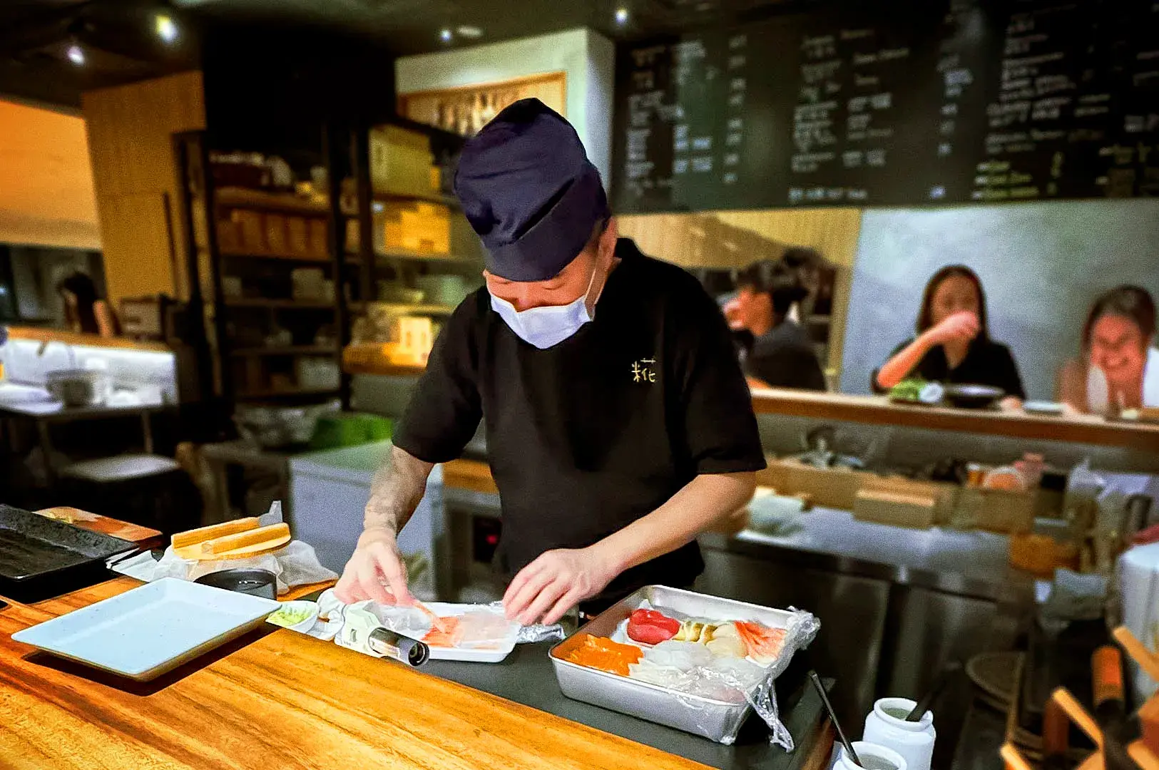 Chef preparing fresh sushi and sashimi at Koji Sushi Bar near City Hall MRT in Singapore