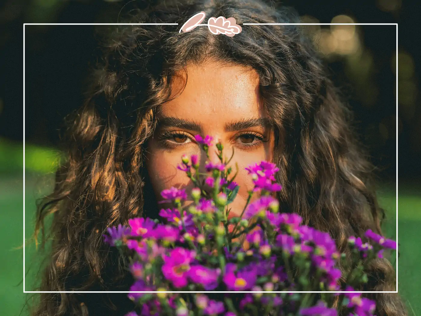 Woman with curly hair holding a bouquet of purple flowers - Fabulous Flowers and gifts