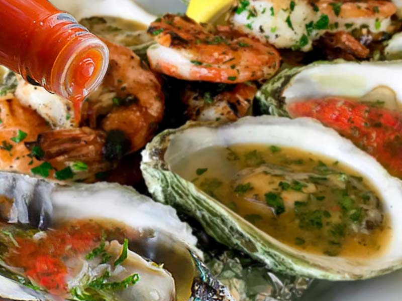 Image showing a sweet and spicy grilled oyster dish made with Red Clay Hot Sauce.