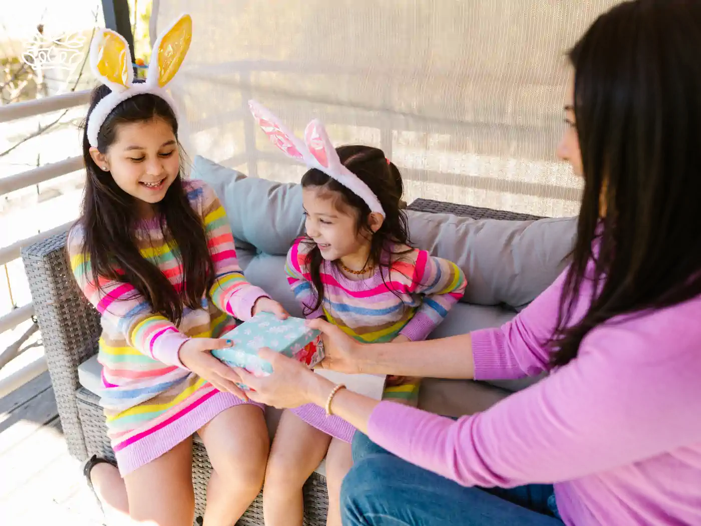 Two young girls with bunny ears receiving a luxury gift box from their mother - Fabulous Flowers and Gifts, Luxury Gift Boxes collection.