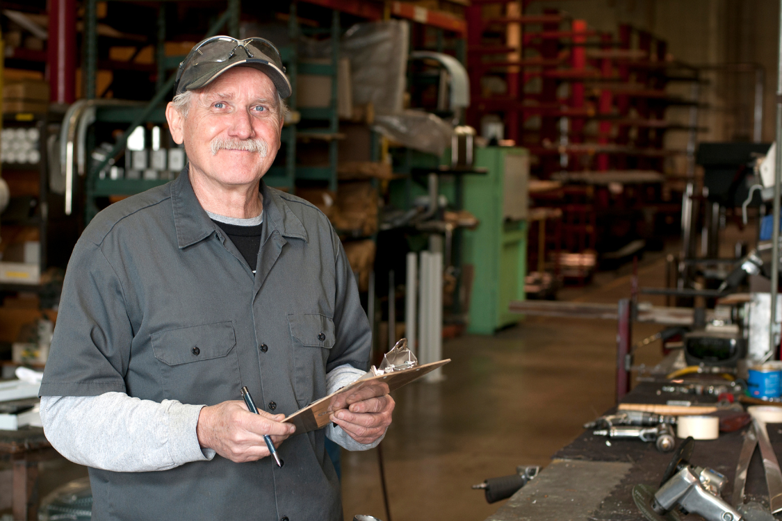 Experienced supplement manufacturer inspecting production facility for quality control
