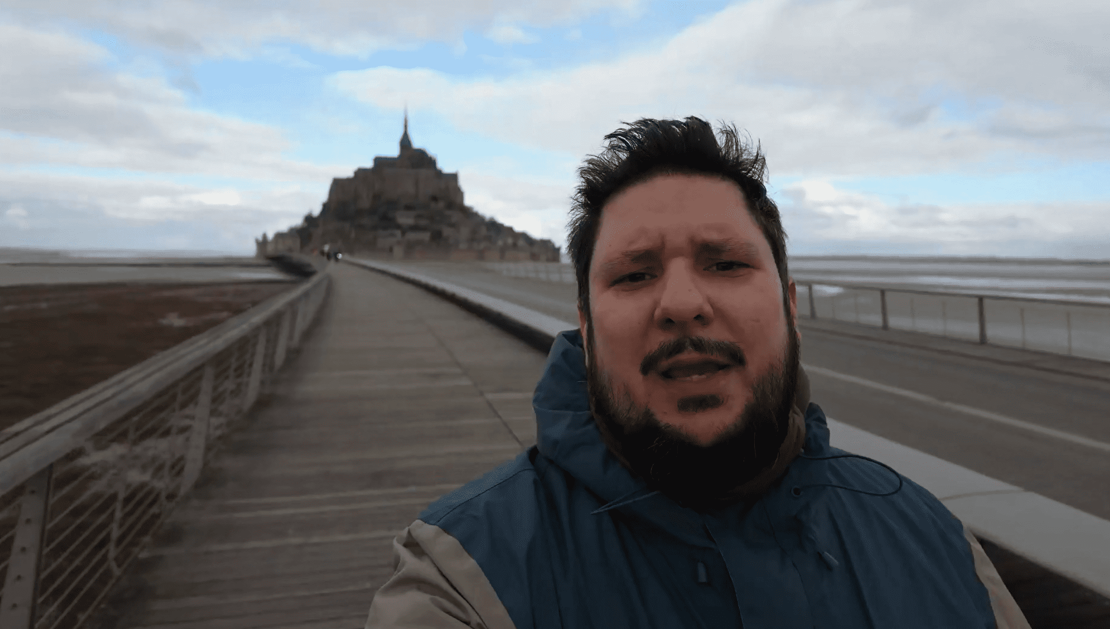 Tim auf dem Fußweg zum Le Mont-Saint-Michel: Ein großer Holzsteg bringt dich trockenen Fußes zum Berg