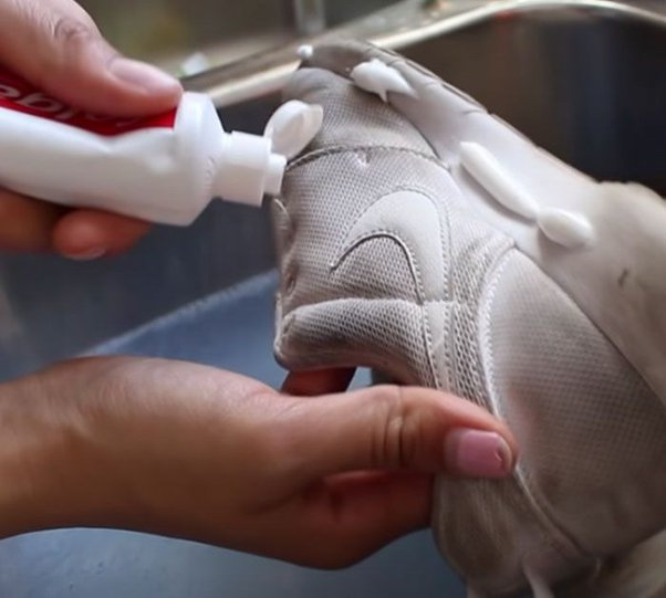 Cleaning shoes with white toothpaste
