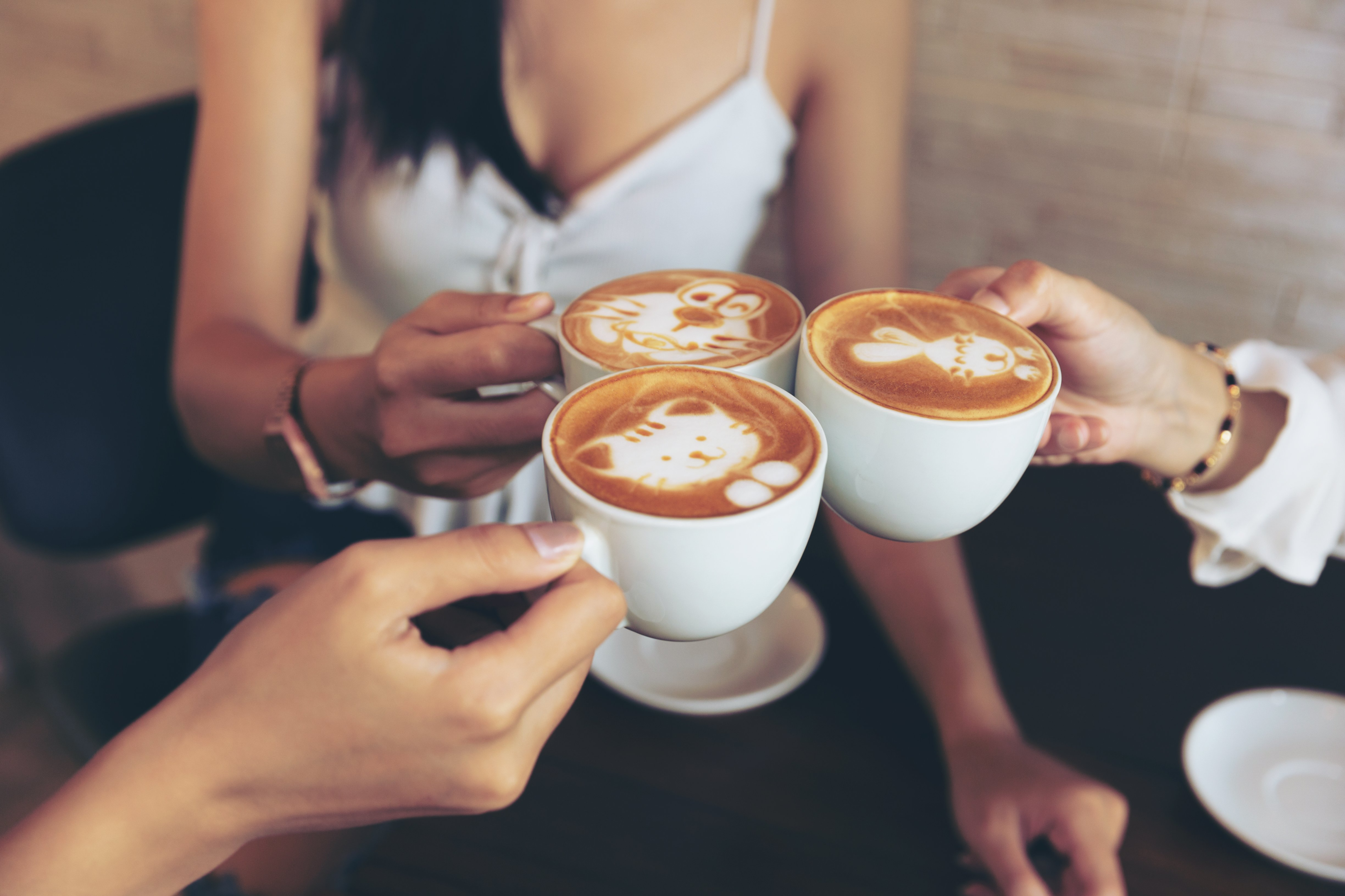 Group of 3 female friends drinking cappuccino's together.